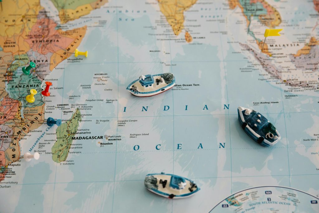 Detailed world map featuring toy ships and colored pins plotted over the Indian Ocean.